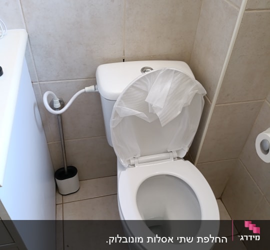 אסלה עם נייר טואלט בחדר אמבטיה